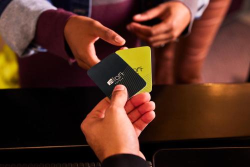 a group of people holding up a credit card at Aloft Me'aisam, Dubai in Dubai