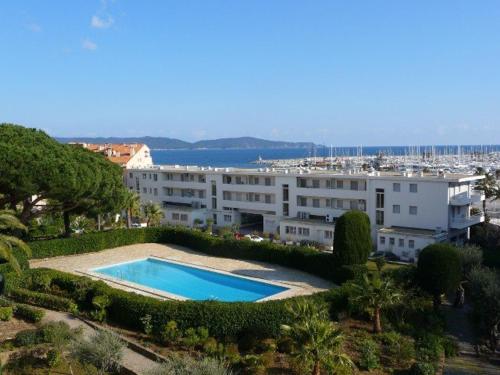 un grand bâtiment avec une piscine devant dans l'établissement Studio climatisé, accès piscine, terrasse, proche plage et commerces - FR-1-226B-179, à Cavalaire-sur-Mer