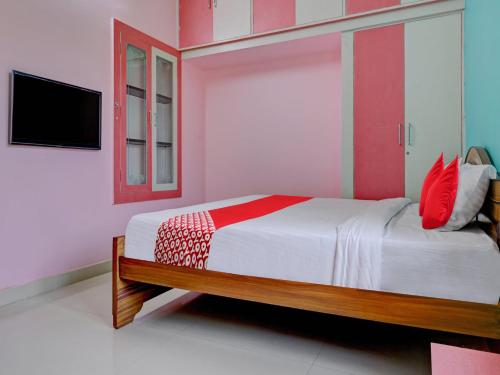 Sharin Service Apartments في سالم: غرفة نوم مع سرير وتلفزيون على الحائط