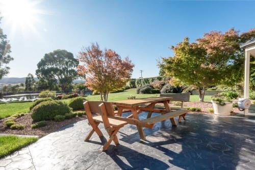 a wooden picnic table and bench in a park at Rural Apartment with Stunning Views in Relbia