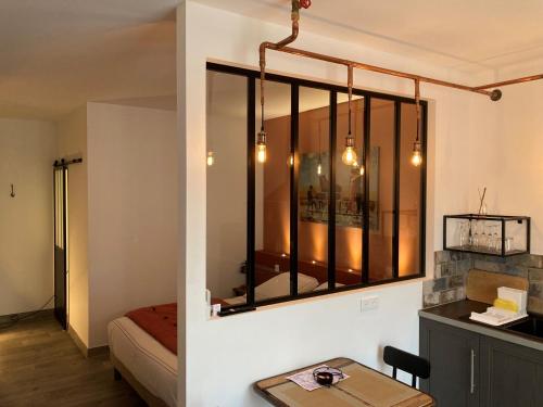 リル・シュル・ラ・ソルギュにあるLes loftsのベッド、テーブル、窓が備わる客室です。
