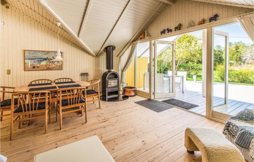 a living room with a table and a wood stove at Three-Bedroom Holiday Home In Skalskor in Skælskør
