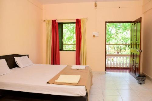 a bedroom with a bed and a large window at Comforts Stays Kihim in Kīhīm