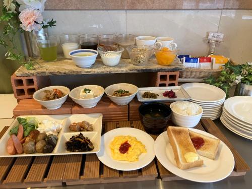 a table with plates of food and bowls of food at Hotel Kakegawa Hills in Kakegawa