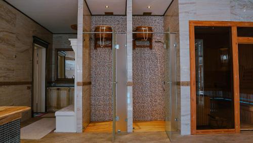Pokój ze szklanymi drzwiami i ceglanymi ścianami w obiekcie ALDONZA CHALET Akkol w mieście Aqköl