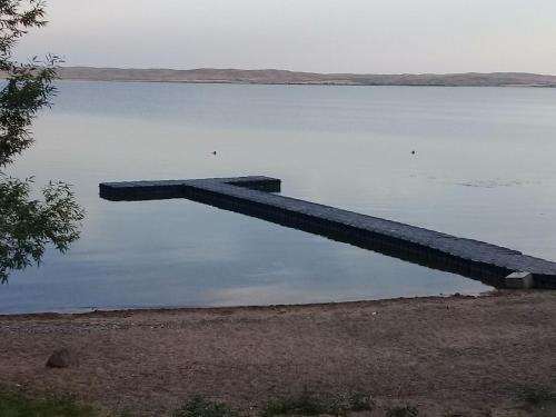 a dock in the middle of a body of water at Зона Отдыха Тихий Залив in Topar