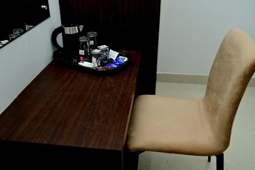 uma cadeira ao lado de uma mesa de madeira com uma chávena de café em The Mallika Sapphire em Chikmagalur