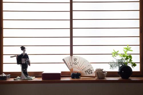 a shelf with a samurai figurine and a window at 川と森の静かな街に朝陽の見える部屋 無料駐車場 in Sapporo
