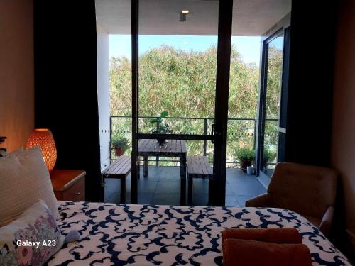 a bedroom with a bed and a view of a balcony at Lux 2 Bed 2 Bath Apartment in the Heart of Dickson, Canberra in Canberra