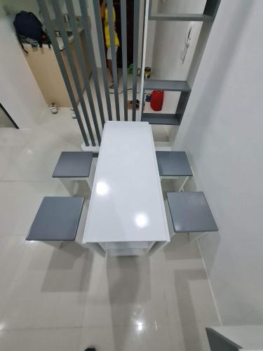 una mesa blanca en una habitación con escaleras en Condo Unit @ Baguio en Baguio