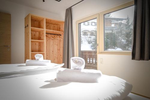 three beds with white pillows in a room with a window at WOLF Apartments Padaun in Vals