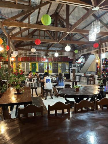 Oasis Resthouse في San Agustin: مطعم بالطاولات والناس جالسين على الكراسي