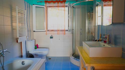 a bathroom with a tub and a toilet and a sink at Villa Bettina 2nd floor in Afionas