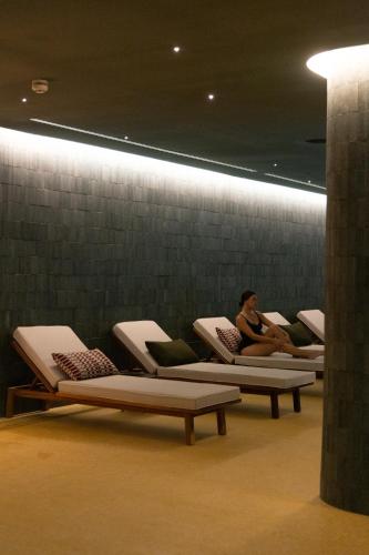 a woman sitting on a row of chairs in a room at El Fuerte Marbella in Marbella
