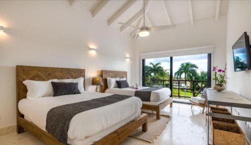 um quarto com 2 camas e uma varanda em Gorgeous Four Bedroom Villa em Cajuiles