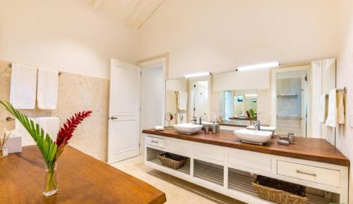 baño con 2 lavabos y espejo grande en Gorgeous Four Bedroom Villa, en Cajuiles