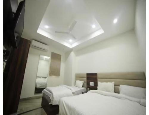 a hotel room with two beds and a mirror at HOTEL SHRI RAM RESIDENCY, Agra in Agra