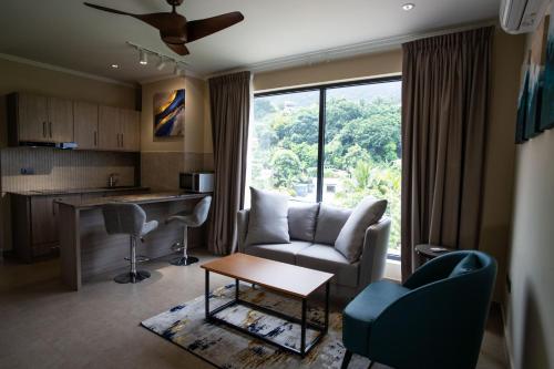 a living room with a couch and a table at Thalassa Seychelles in Beau Vallon