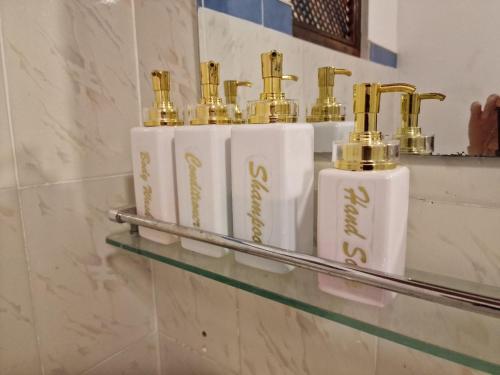um grupo de frascos de perfume em uma prateleira em uma casa de banho em Panorama Beach Hotel em Tangalle