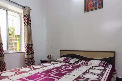 una camera con un letto con copriletto viola e bianco di House By The Lake a Calcutta