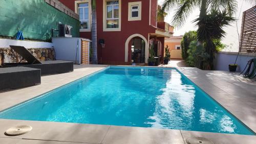 a blue swimming pool in front of a house at Casa Viera in Buzanada
