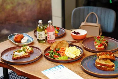 una mesa de madera con platos de comida. en Hotel Park Residency By BYOB Hotels en Nueva Delhi