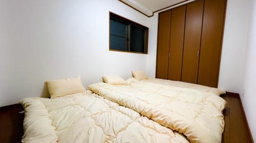 a large bed in a room with a window at NEW【駅から2分】USJ空庭難波梅田まで10分!まるごと一軒家貸し切り!大人数宿泊可能!駐車場有 in Osaka