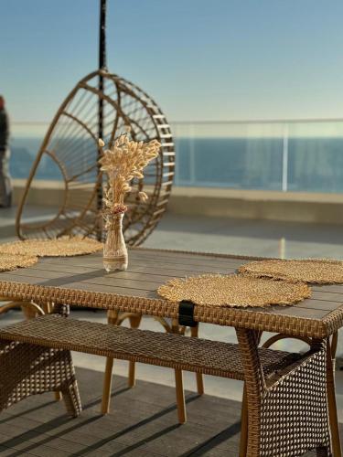 繩金塔的住宿－Holiday Apartment Aldi，一张带椅子的木桌和一个花瓶