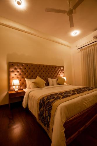 a bedroom with a large bed with two lamps at Manthra Leisure in Kandy