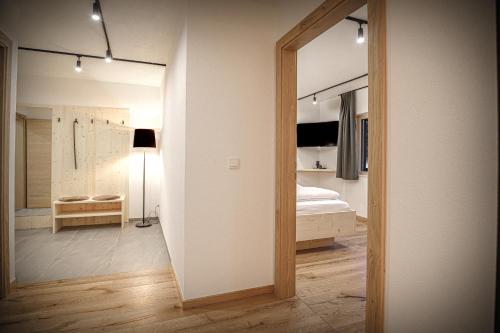 a room with a bedroom with a bed and a mirror at WOLF Apartments Padaun in Vals