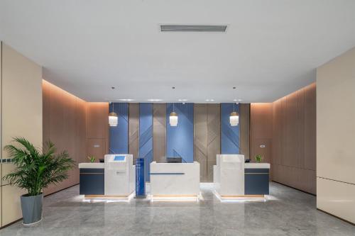 un vestíbulo de oficina con escritorios y paredes azules y marrones en Holiday Inn Express Bazhong Center, an IHG Hotel, en Bazhong