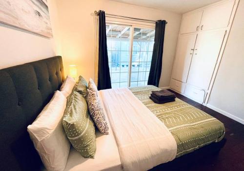 1 dormitorio con cama con almohadas y ventana en 40223 Fremont Entire Coze 3brs house Free Parking nd AC en Fremont
