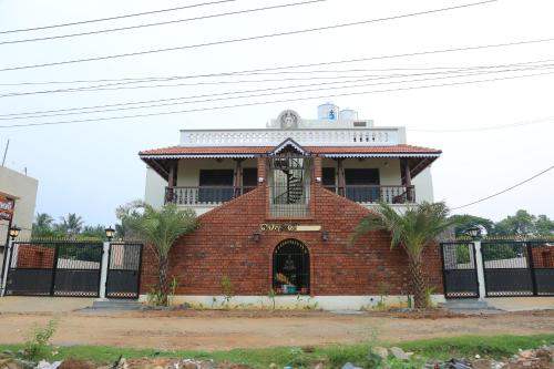 a brick building with a clock on top of it at Ponni Homestay Kumbakonam in Kumbakonam