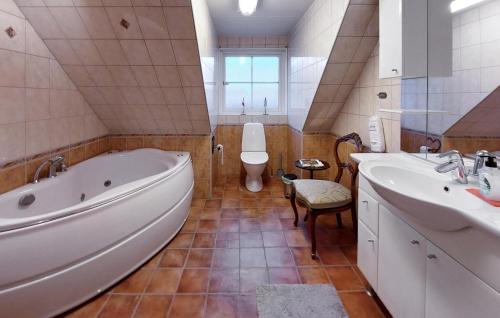 a bathroom with a tub and two sinks and a toilet at 3 Bedroom Beautiful Home In Höganäs in Höganäs