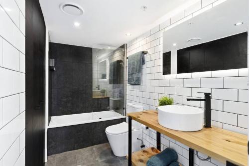 La salle de bains est pourvue d'un lavabo, de toilettes et d'une baignoire. dans l'établissement "Boutique Sky Villa" by Inn Paradise, à Gold Coast