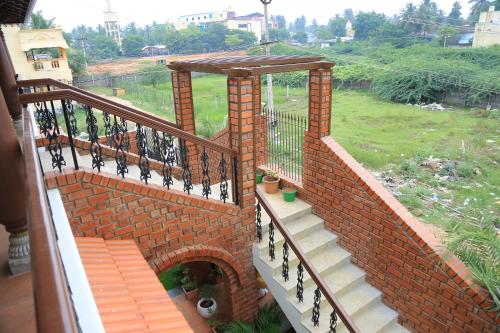 a stairway with a brick wall and a balcony at Ponni Homestay Kumbakonam in Kumbakonam