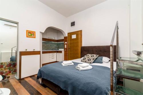 een slaapkamer met een bed met handdoeken erop bij Marcel Apartments in Belgrado