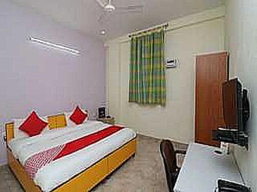 a bedroom with a bed and a desk and a television at OYO Flagship 81283 Sukhsagar in Gurgaon