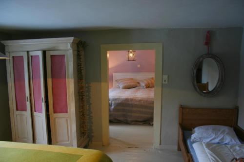 een slaapkamer met een bed en een spiegel bij Tony in Vielsalm
