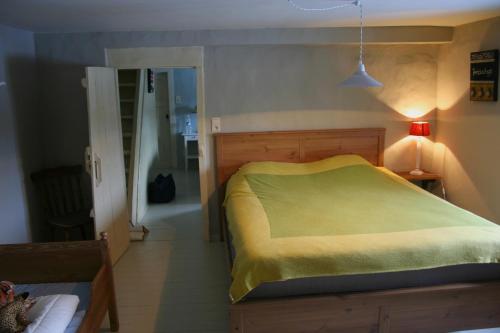 een slaapkamer met een bed met een gele deken bij Tony in Vielsalm