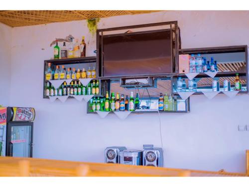 a shelf with bottles on a wall at Planete Hotel in Rubavu