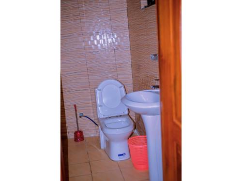 a bathroom with a toilet and a sink at Planete Hotel in Rubavu
