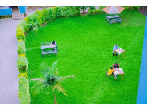 a group of people sitting on benches in a park at Planete Hotel in Rubavu