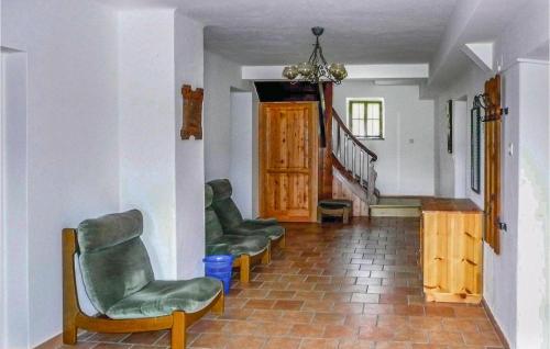 a living room with two chairs and a staircase at Ferienwohnung Mit Badeteich in Ramsau am Dachstein