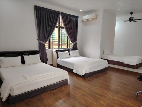 a bedroom with two beds and a window at Mersing Maple Villa in Mersing