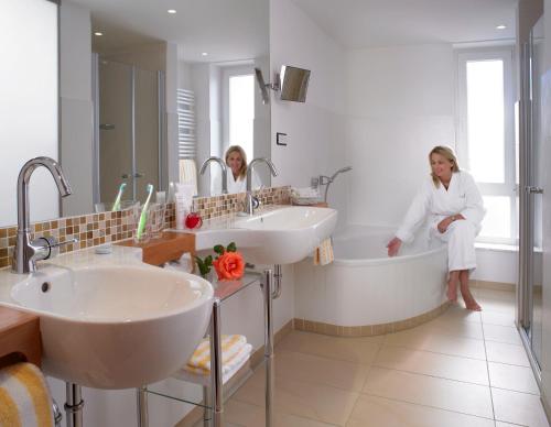 zwei Frauen sitzen in einer Badewanne im Badezimmer in der Unterkunft Hotel Flörke in Langeoog