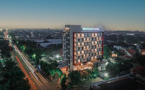 a building with a lit up sign on top of it at Metland Hotel Cirebon by Horison in Cirebon
