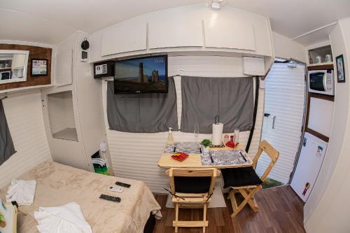 um pequeno quarto com uma mesa numa caravana em Motorhomes na Serra em Teresópolis