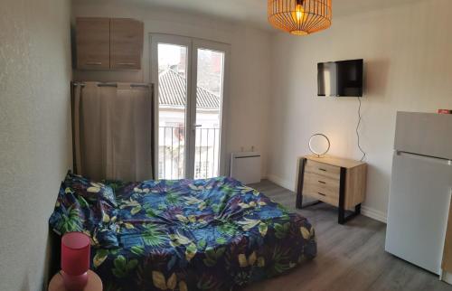 una camera con letto, cassettiera e frigorifero di le cosy du beau lieu immozen 46 a Beaulieu-sur-Dordogne