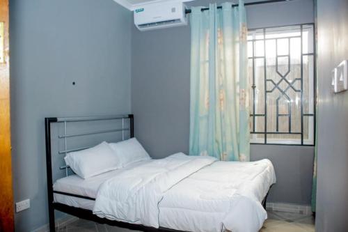 um quarto com uma cama grande e uma janela em Swahili Homes- Ada Estate em Dar es Salaam